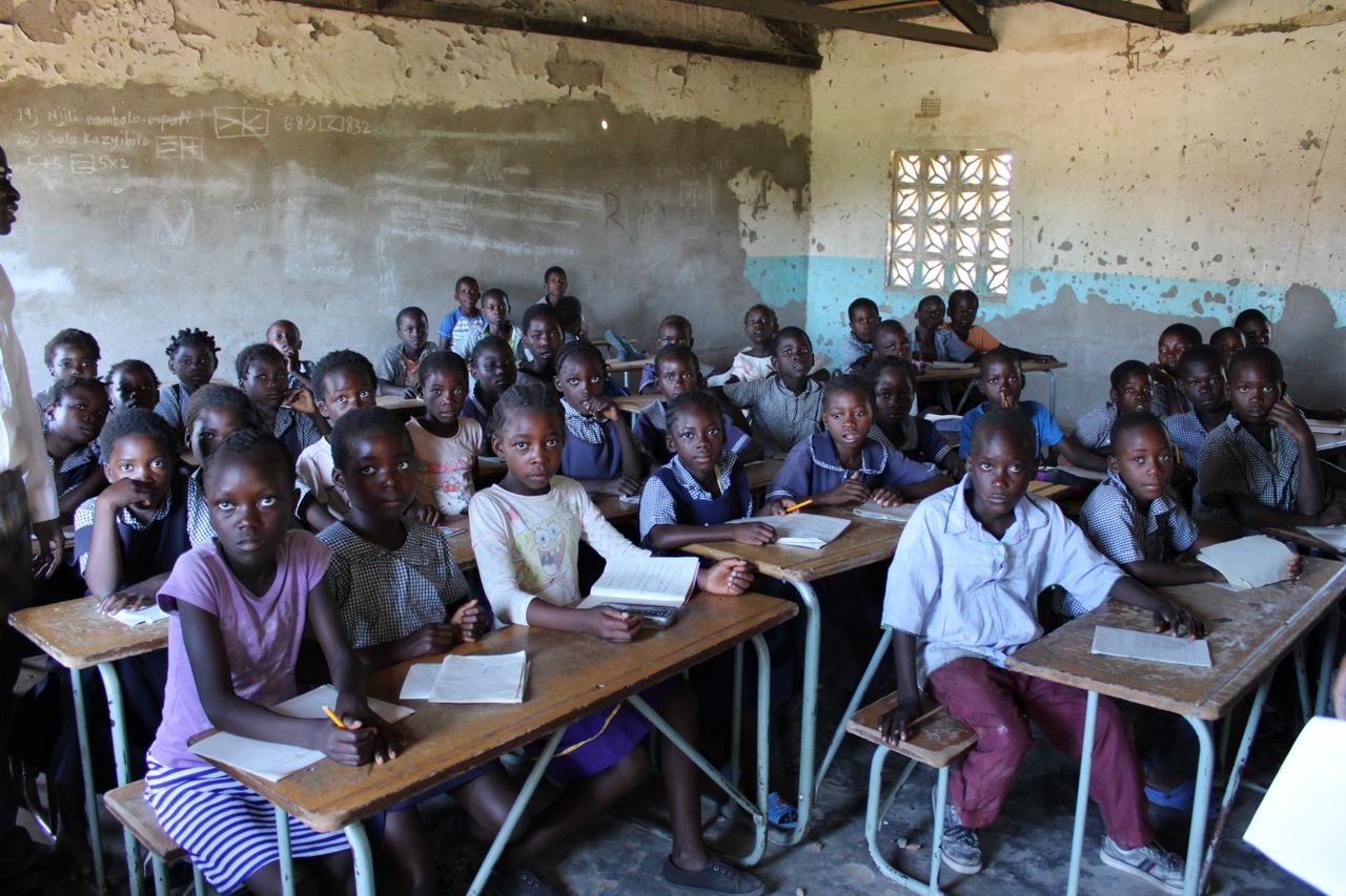 The Art of Drawing Readers In: Your attractive post title goes here A group of children in a classroom in Zambia focused on their studies.